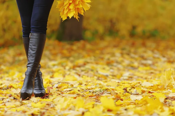 Vrouw voeten in herfst park — Stockfoto