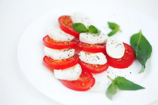 Rebanadas de tomate y mozzarella en un plato —  Fotos de Stock