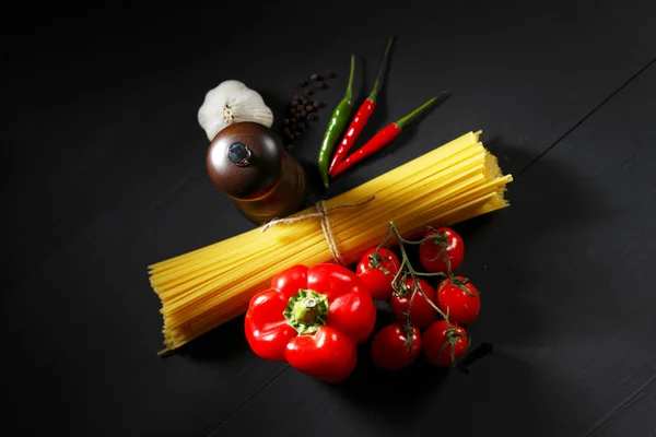 Ingredientes de massas na mesa preta — Fotografia de Stock