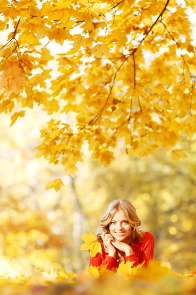 Frau legt sich auf Herbstlaub — Stockfoto