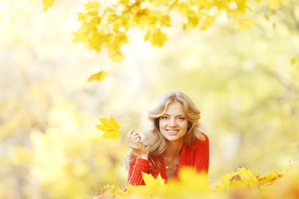 Woman laying on autumn leaves — Stock Photo, Image
