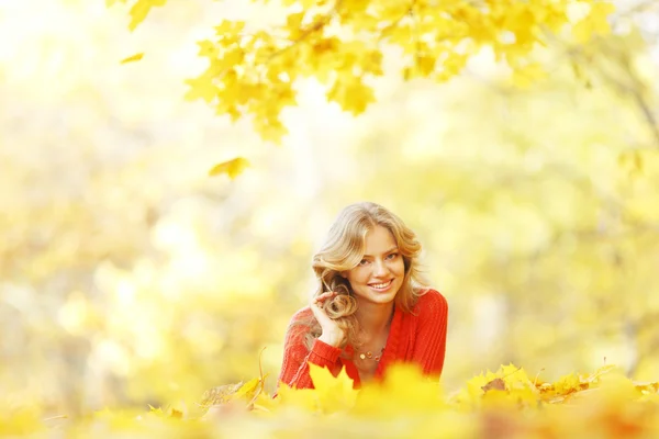 Woman laying on autumn leaves — Stock Photo, Image