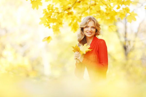 Donna seduta sulle foglie d'autunno — Foto Stock