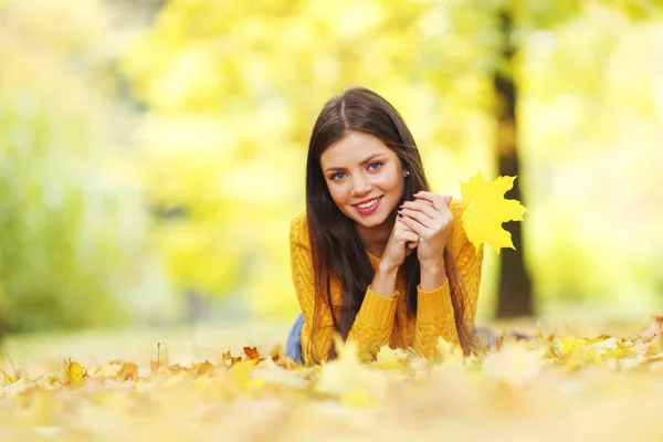 Girl laying on autumn leafs — Stock Photo, Image