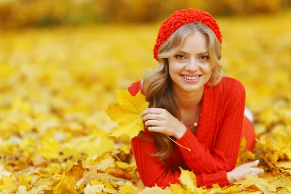 Frau legt sich auf Herbstlaub — Stockfoto