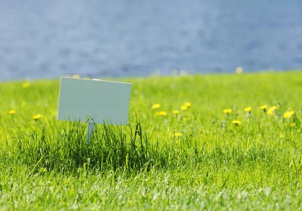 Cartello bianco su erba — Foto Stock
