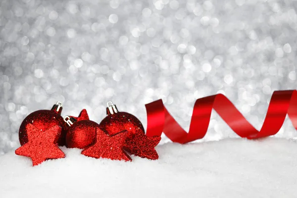 Красное рождественское украшение на снегу — стоковое фото