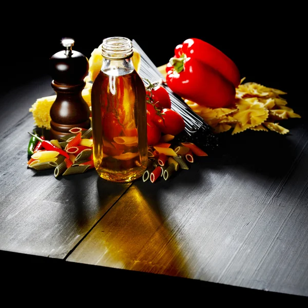 Těstoviny ingredience na černém stole — Stock fotografie