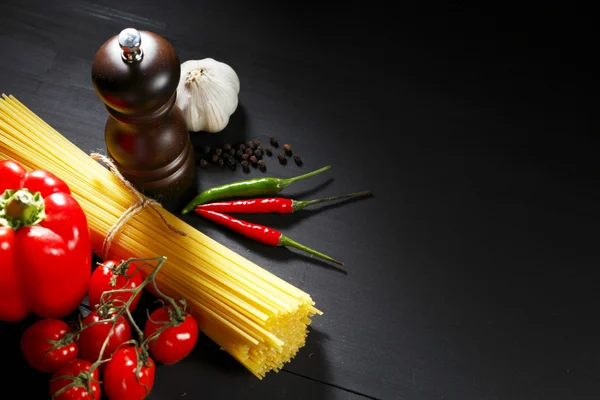 Pasta ingredients on black table — Stock Photo, Image
