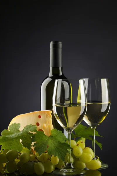 Bílé víno a sýr na černém pozadí — Stock fotografie