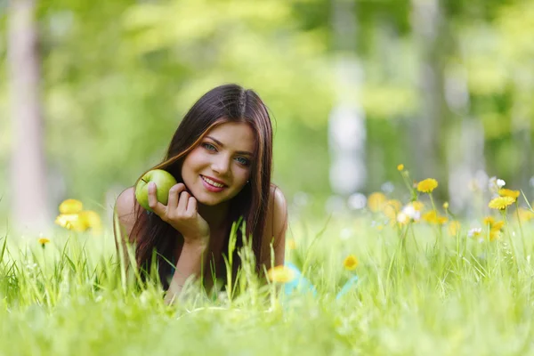 Woman with apple outdoors — Stock Photo, Image