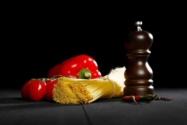 Pasta ingredients on black table — Stock Photo, Image