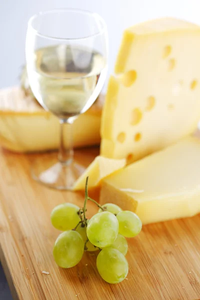 Queijo e vinho em uma mesa de madeira — Fotografia de Stock