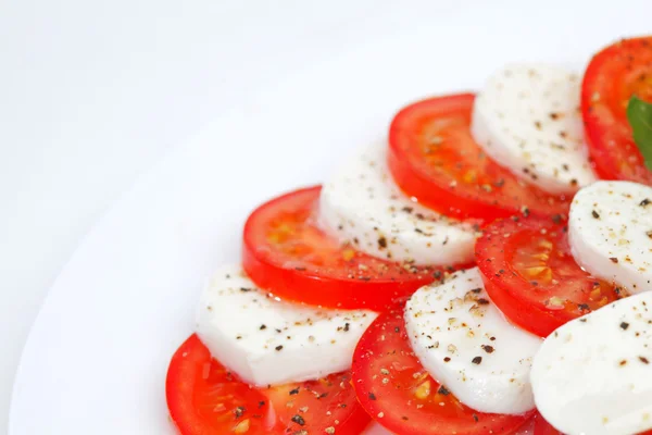 Rebanadas de tomate y mozzarella en un plato —  Fotos de Stock