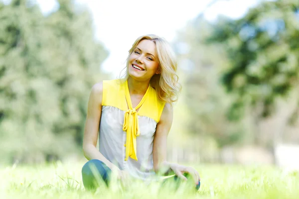 Vrouw zittend op gras — Stockfoto