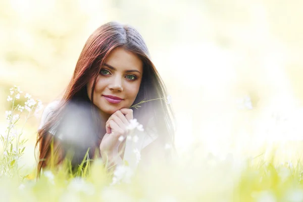 Vrouw leggen in zonnige voorjaar park — Stockfoto