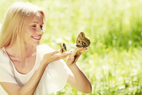 Woman playing with butterfly — Stock Photo, Image