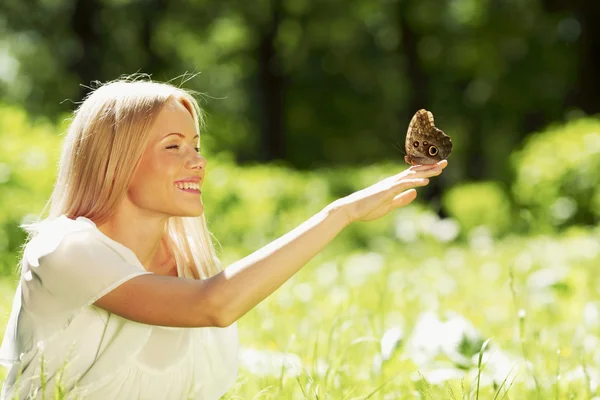 Woman playing with butterfly — Stock Photo, Image