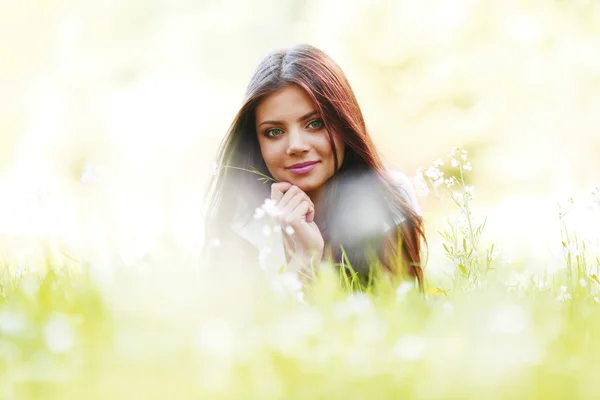 Menina morena bonita deitado na grama — Fotografia de Stock