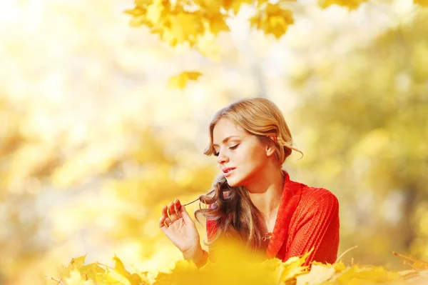 Sonbahar yaprakları üzerinde döşeme kadın — Stok fotoğraf