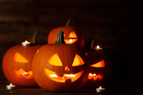 Grupp Glödande Halloween Pumpa Lyktor Och Brinnande Ljus Mörkt Trä — Stockfoto