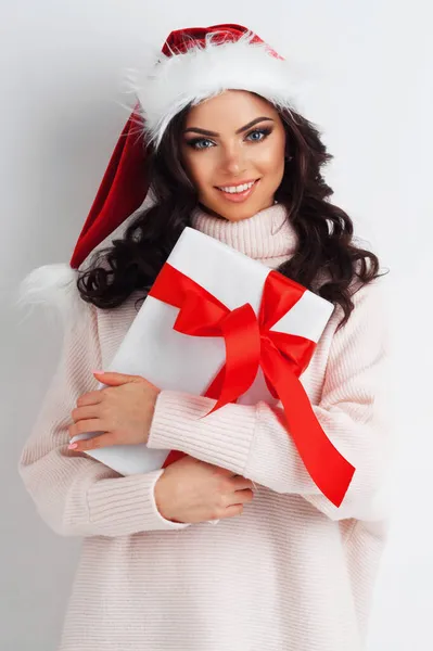 美しいですカジュアル女性の写真でサンタ帽子で現在のボックスとともに赤いリボン弓上の白 — ストック写真