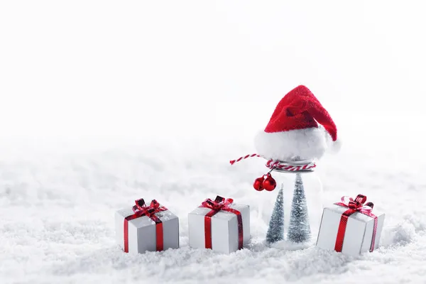 Kerstdecor Sneeuw Geschenken Met Rode Strikken Kerstman Hoed Witte Kopieerruimte — Stockfoto