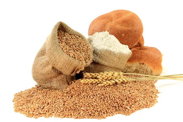 Syrové pšeničných zrn, mouky, wheatears a celozrnné housky v pytlovina pytle na bílém. — Stock fotografie