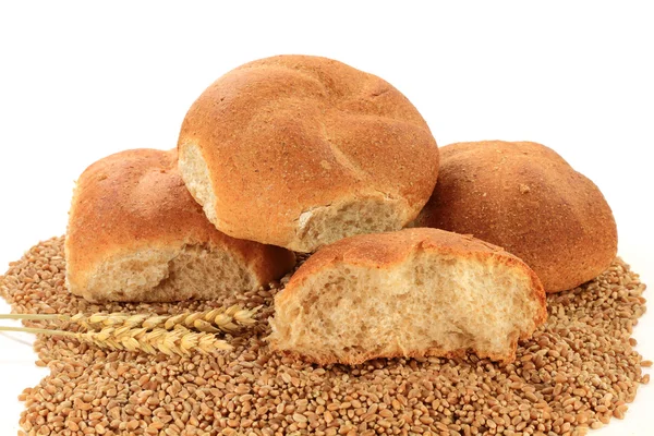 Nezpracovaná pšenice jader, wheatears a celozrnné housky — Stock fotografie