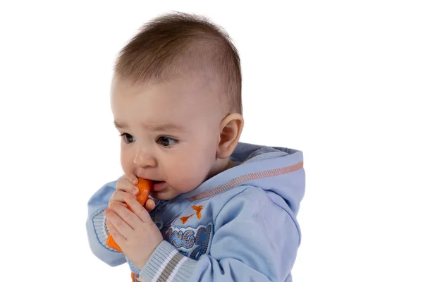 Smiling baby eats carrot — Stock Photo, Image