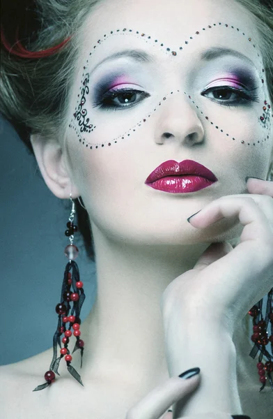 Mooi meisje met een masker en make-up — Stockfoto