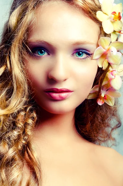 Jeune portrait de beauté avec des fleurs d'orchidée — Photo