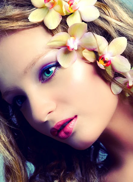 Retrato de beleza jovem com flores de orquídea — Fotografia de Stock
