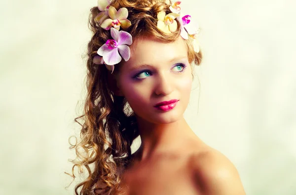 Retrato de menina bonita jovem com flores de orquídea — Fotografia de Stock