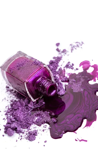 Esmalte de uñas púrpura y sombra de ojos aplastada sobre fondo blanco — Foto de Stock