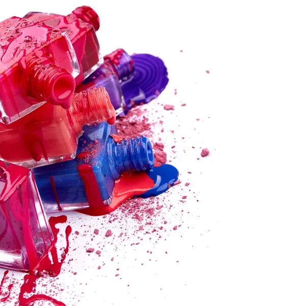Bottles with spilled nail polish and crushed eye shadow — Stock Photo, Image