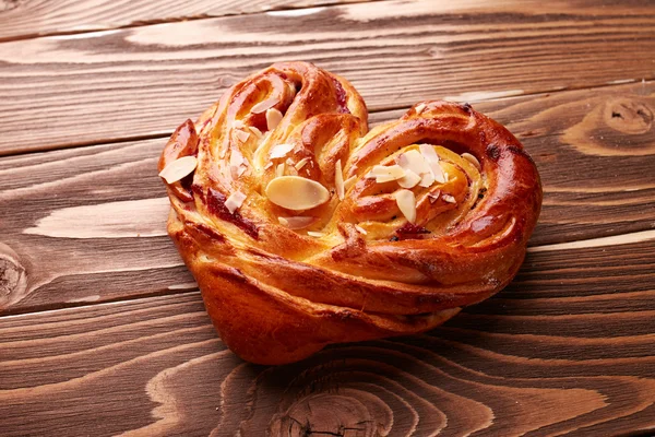 Tasty bun over wooden background — Stock Photo, Image