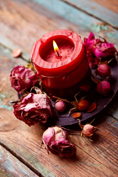 Red candle with dry roses — Stock Photo, Image