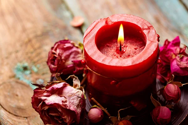 Červená svíčka s suchý růže — Stock fotografie