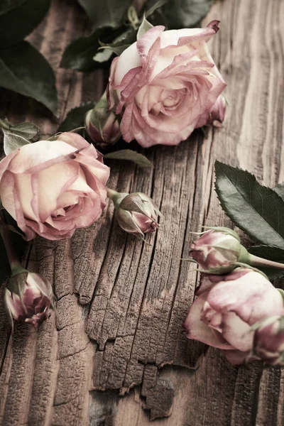 在老式木板背景上的几束玫瑰 — 图库照片