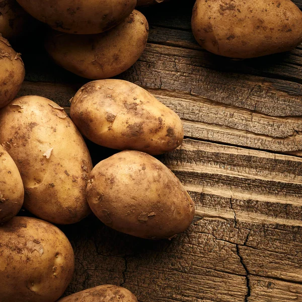 Potatoes over wooden background. Vintage food still life