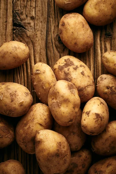 Potatoes over wooden background. Vintage food still life