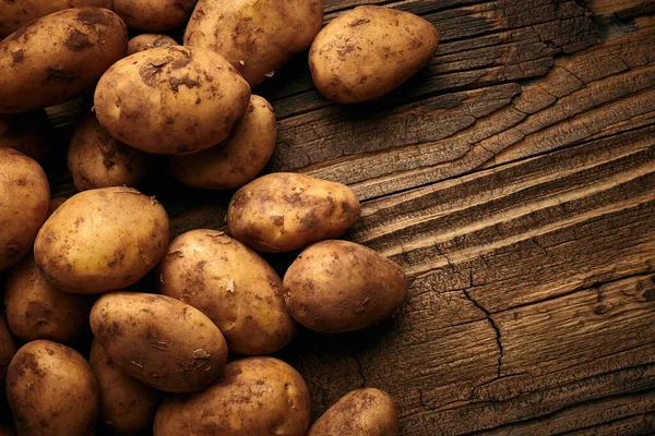 Potatoes over wooden background. Vintage food still life