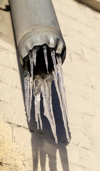 Eiszapfen an einem Abflussrohr — Stockfoto