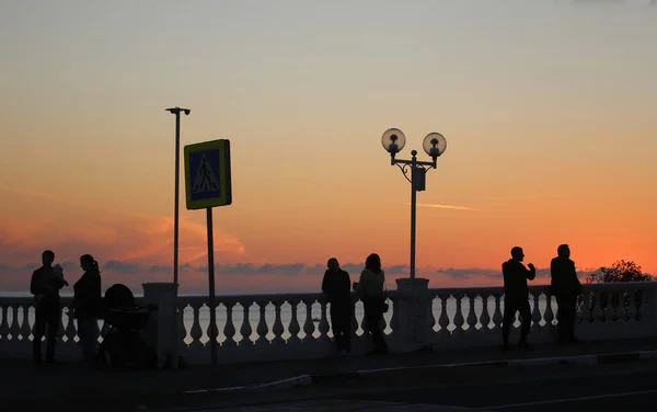 Foto Puesta Sol Brillante Con Siluetas Personas Orilla —  Fotos de Stock