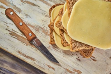 Köy ahşap arka planda dilimlenmiş peynir parçaları, peynirli sandviçler.