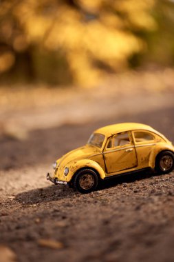 Büyük dünyadaki küçük sarı oyuncak araba.