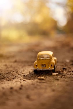 Büyük dünyadaki küçük sarı oyuncak araba.