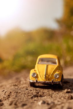 Büyük dünyadaki küçük sarı oyuncak araba.
