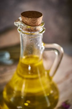 Kırsal bir arka planda bir şişe organik zeytinyağı.